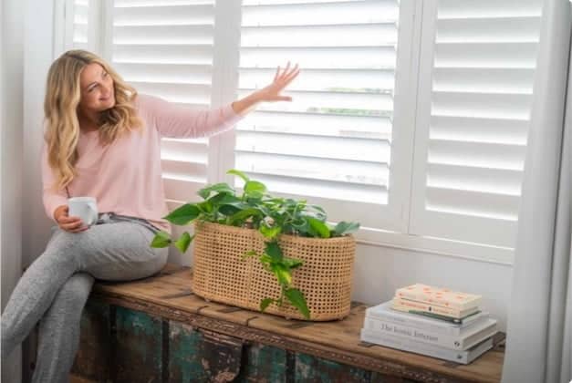 Woman Touching Blinds — Window Coverings in Bundaberg, QLD